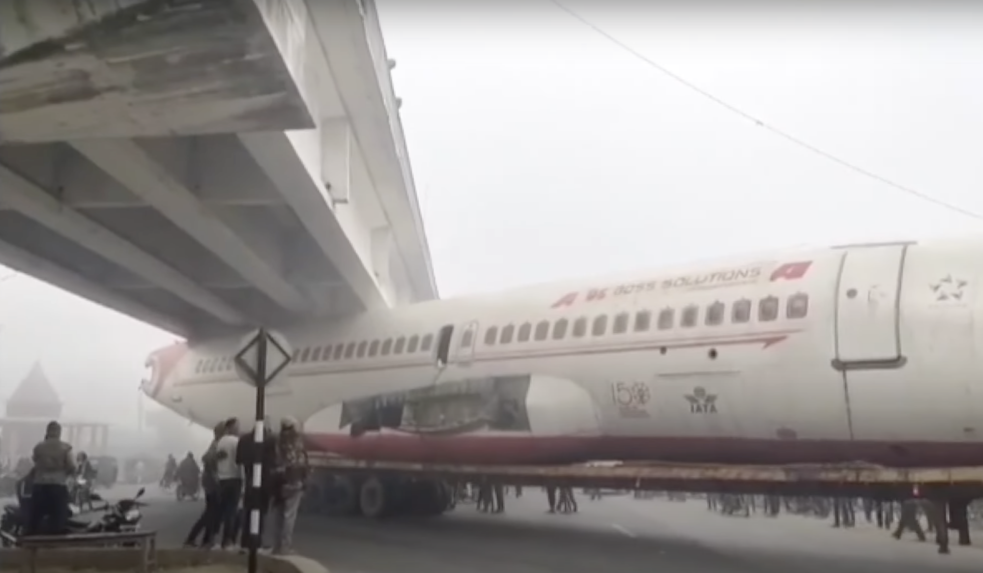 An Air India-branded plane gets stuck under a bridge, but the company has nothing to do with it. Video.