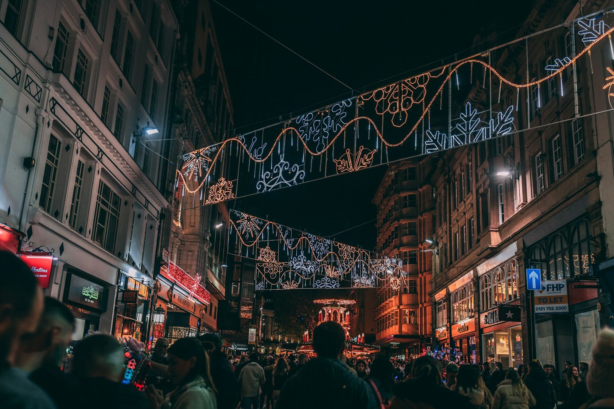 Christmas lights and crowds at a festive market in a city