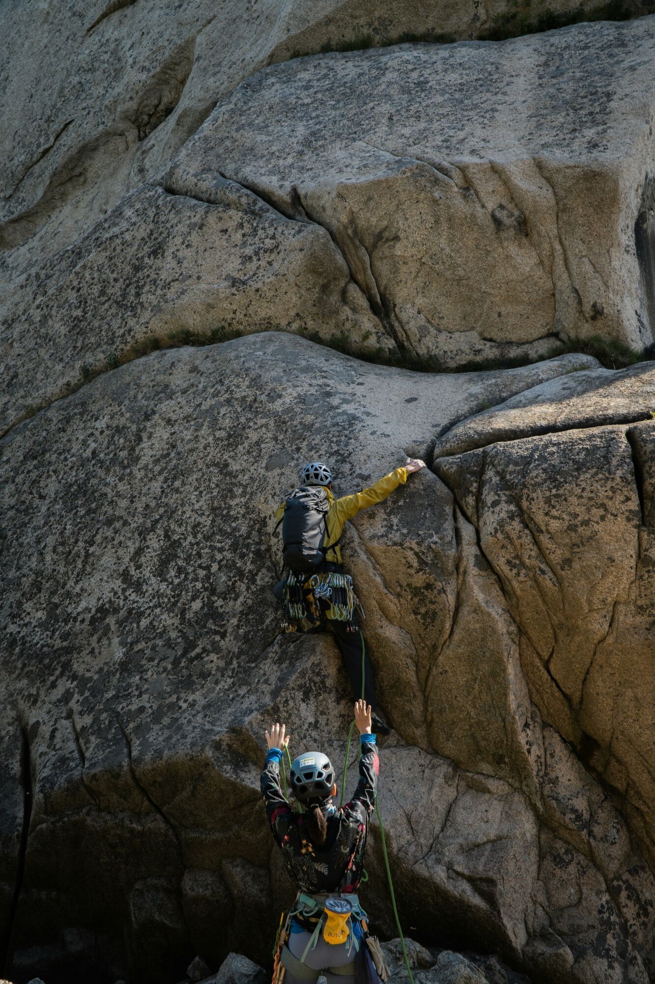 a man climbing up the side of a large rock