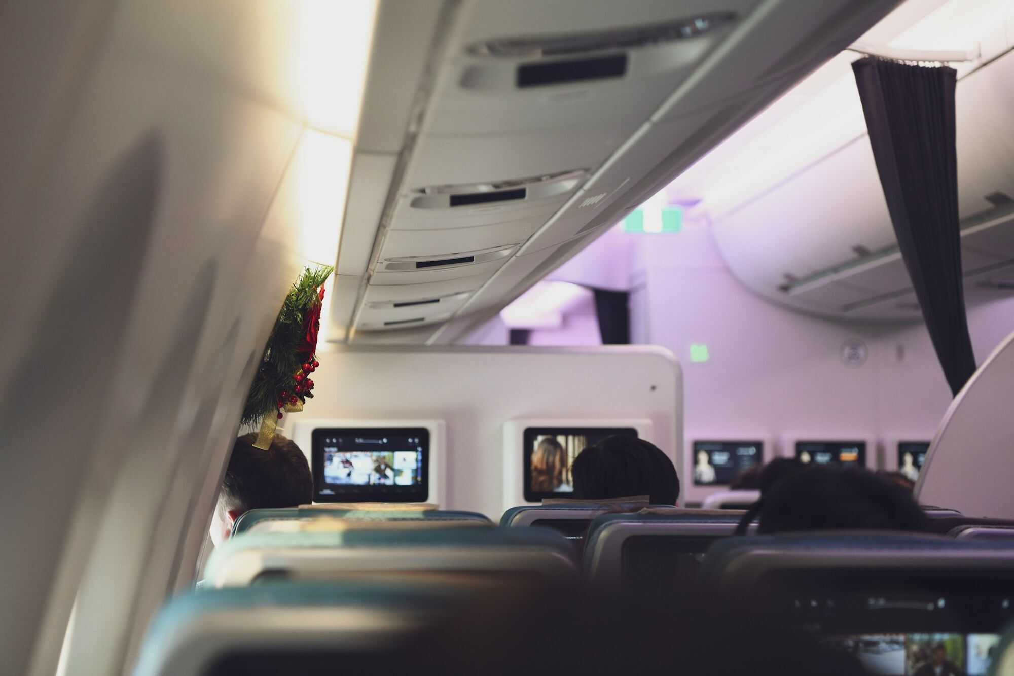 Passengers watching inflight entertainment on seatback screens during a flight