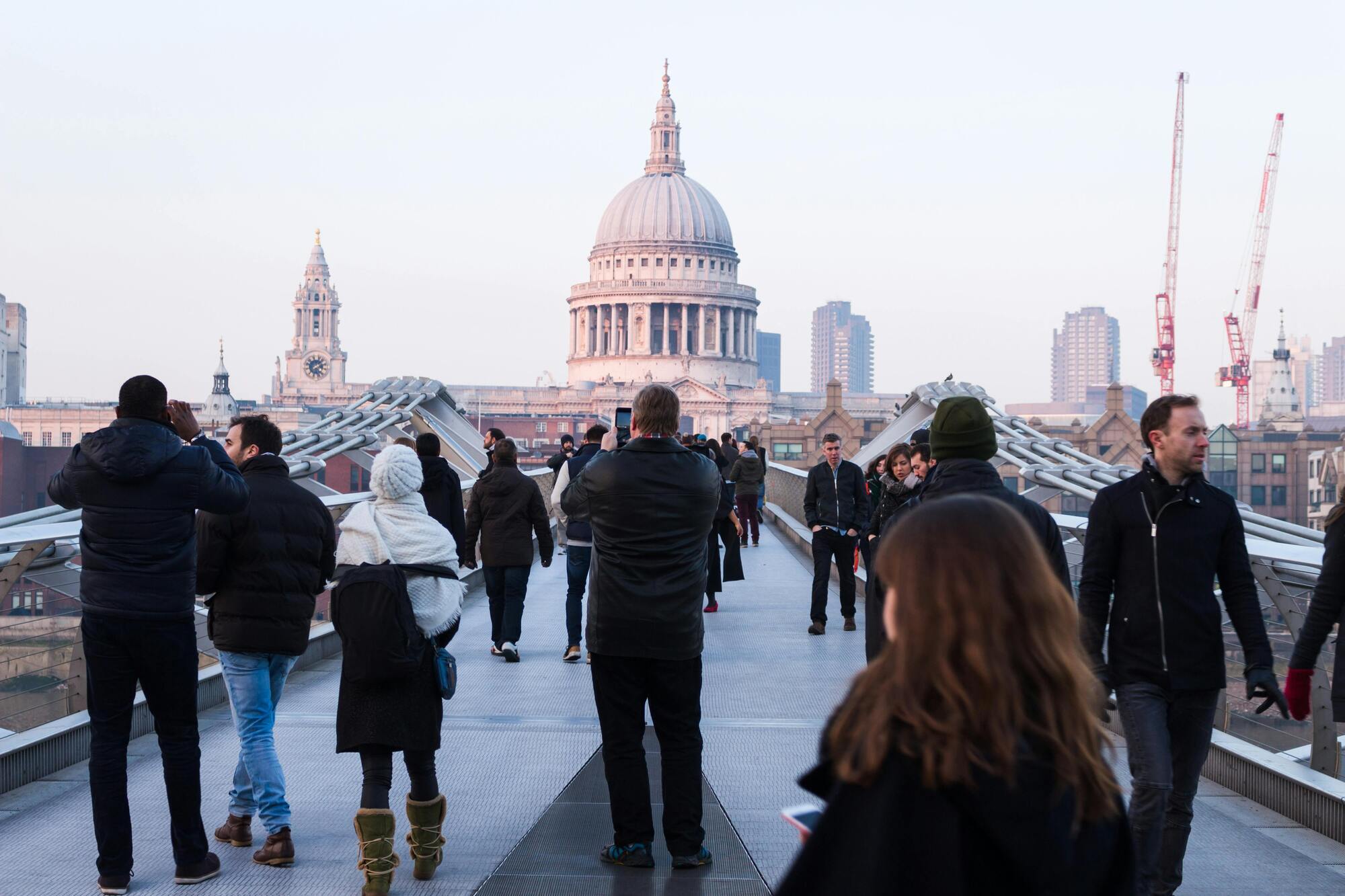 People walking on Millennium Bridge towards St. Paul’s Cathedral in London