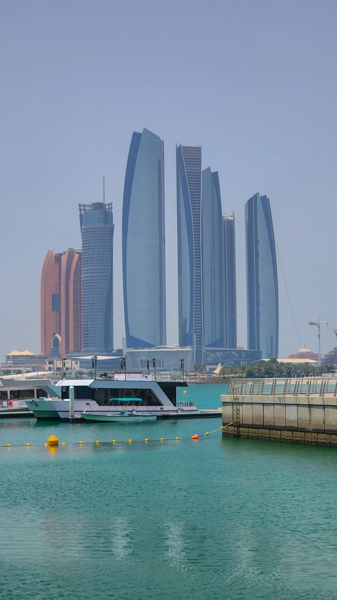 Skyscrapers of Abu Dhabi skyline with boats in the foreground