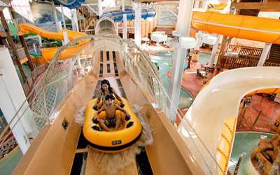 The best indoor water parks in the US for year-round summer vacations. Places to ride big water slides and waves