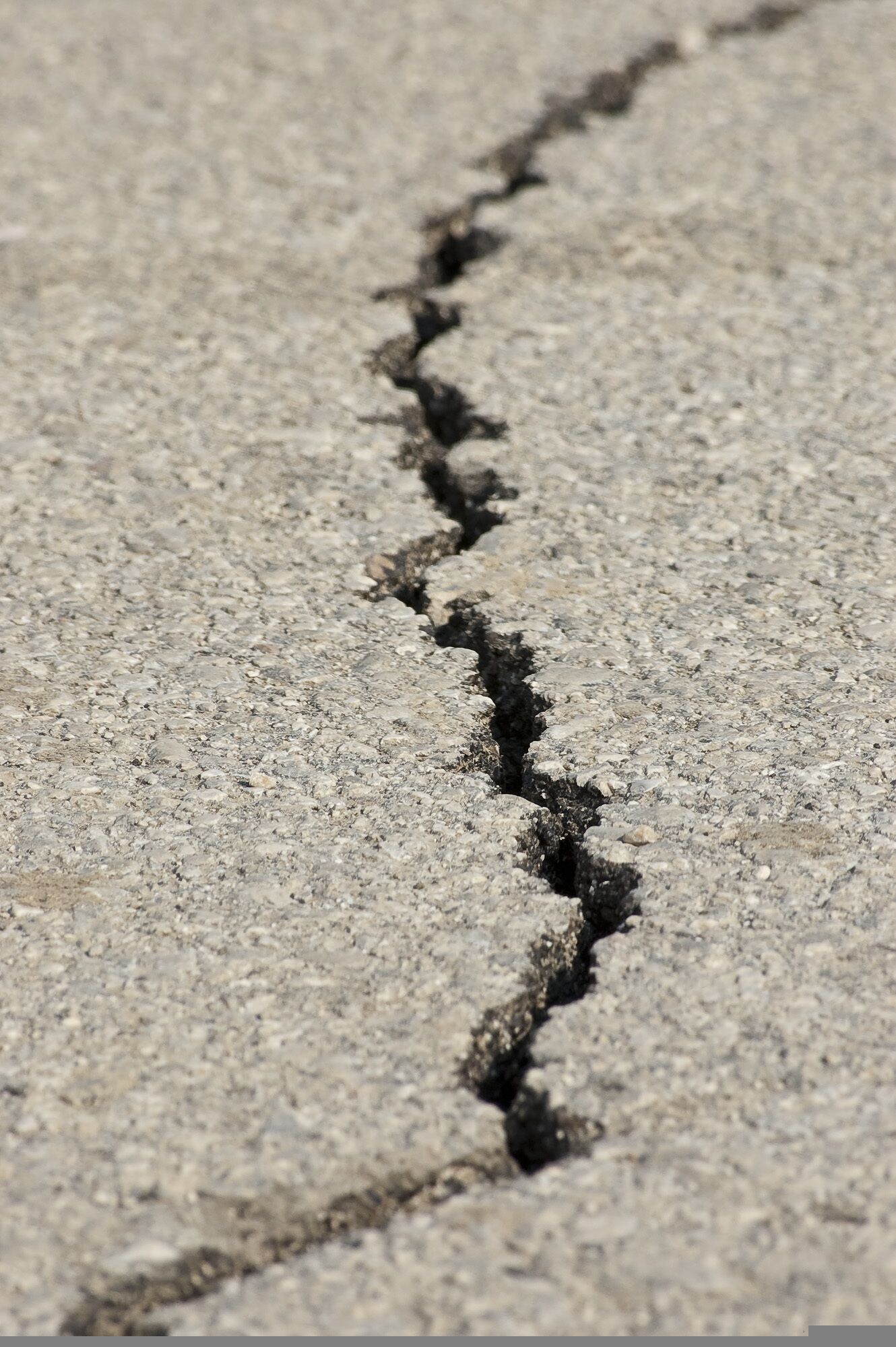 Close-up of a cracked asphalt surface after an earthquake