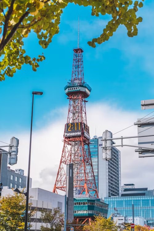 Sapporo TV Tower against blue sky with nearby buildings