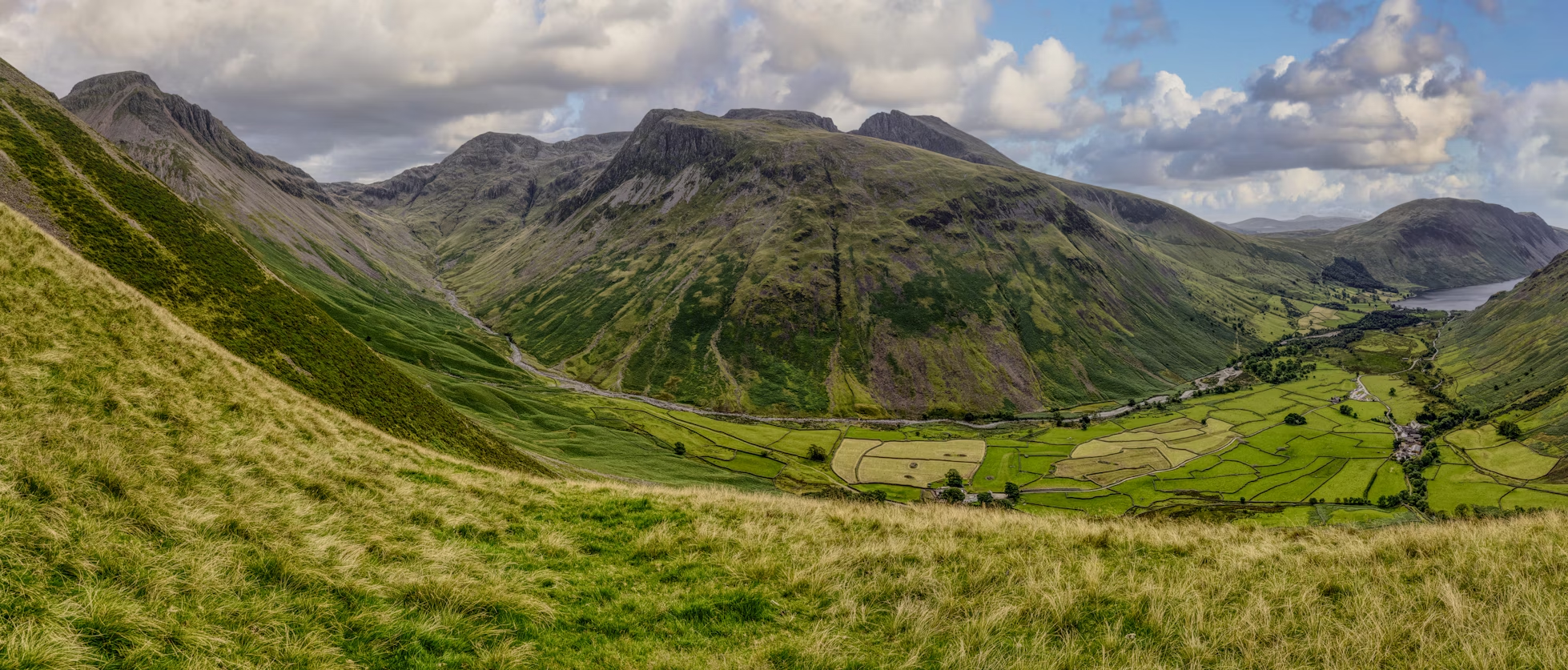 Panoramic view of the English Lake District mountains and valley under partly cloudy skies