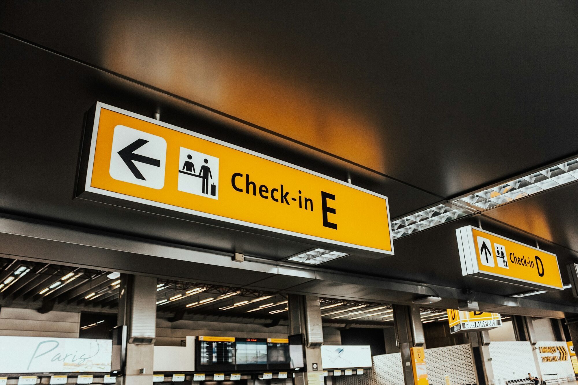Airport check-in sign above passenger area