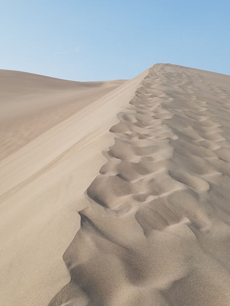 Sand dunes under clear blue sky