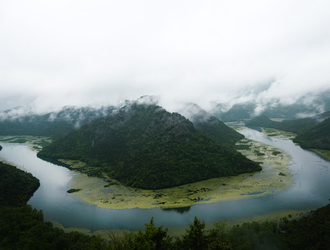 Scenic view of Skadar Lake surrounded by misty mountains
