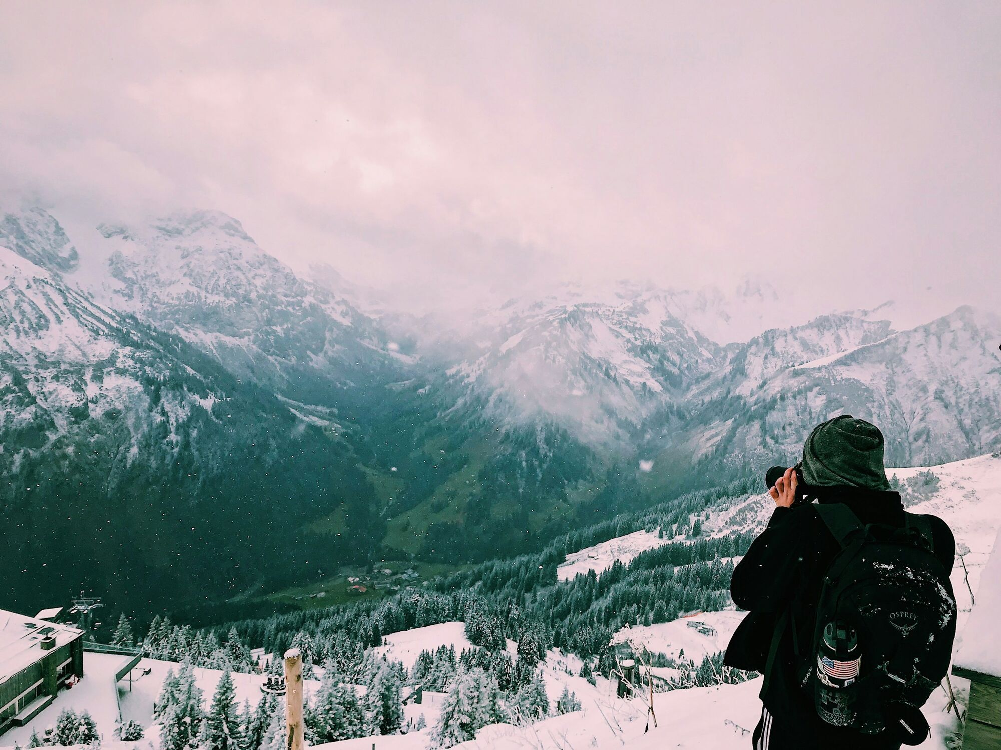 Traveller taking a photo of snowy Alpine mountains near Salzburg