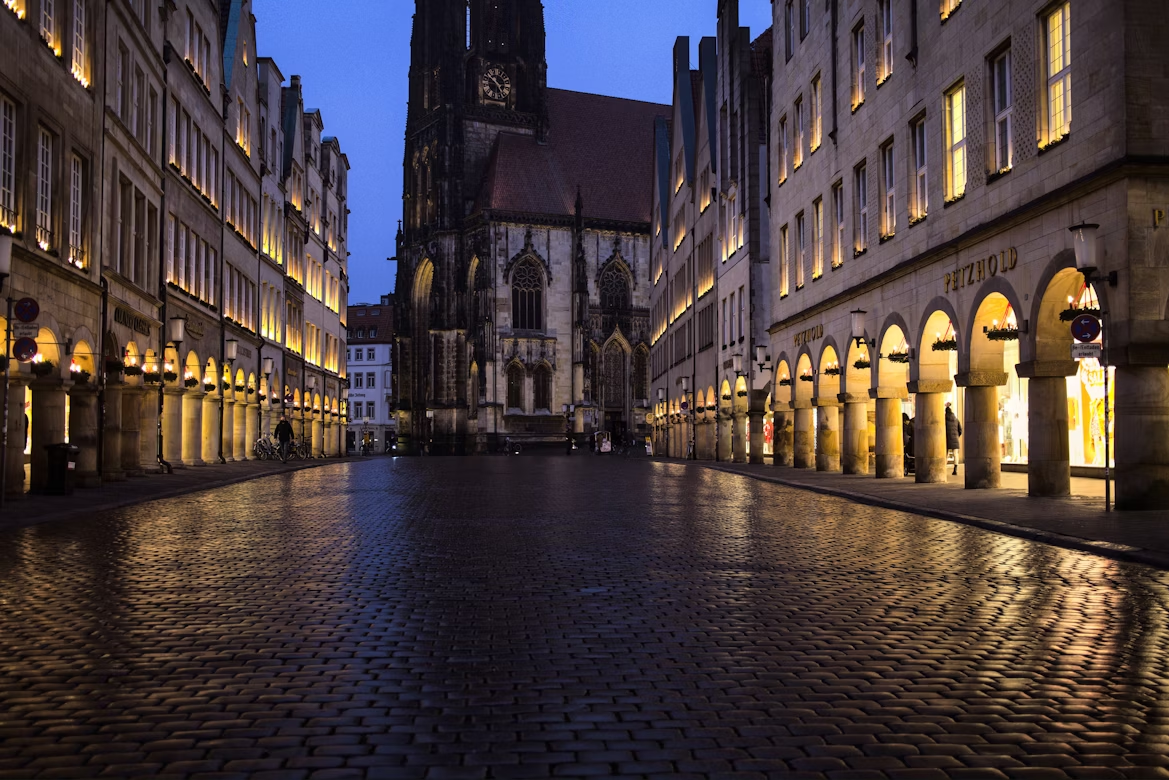Evening view of Prinzipalmarkt square in Münster with illuminated buildings