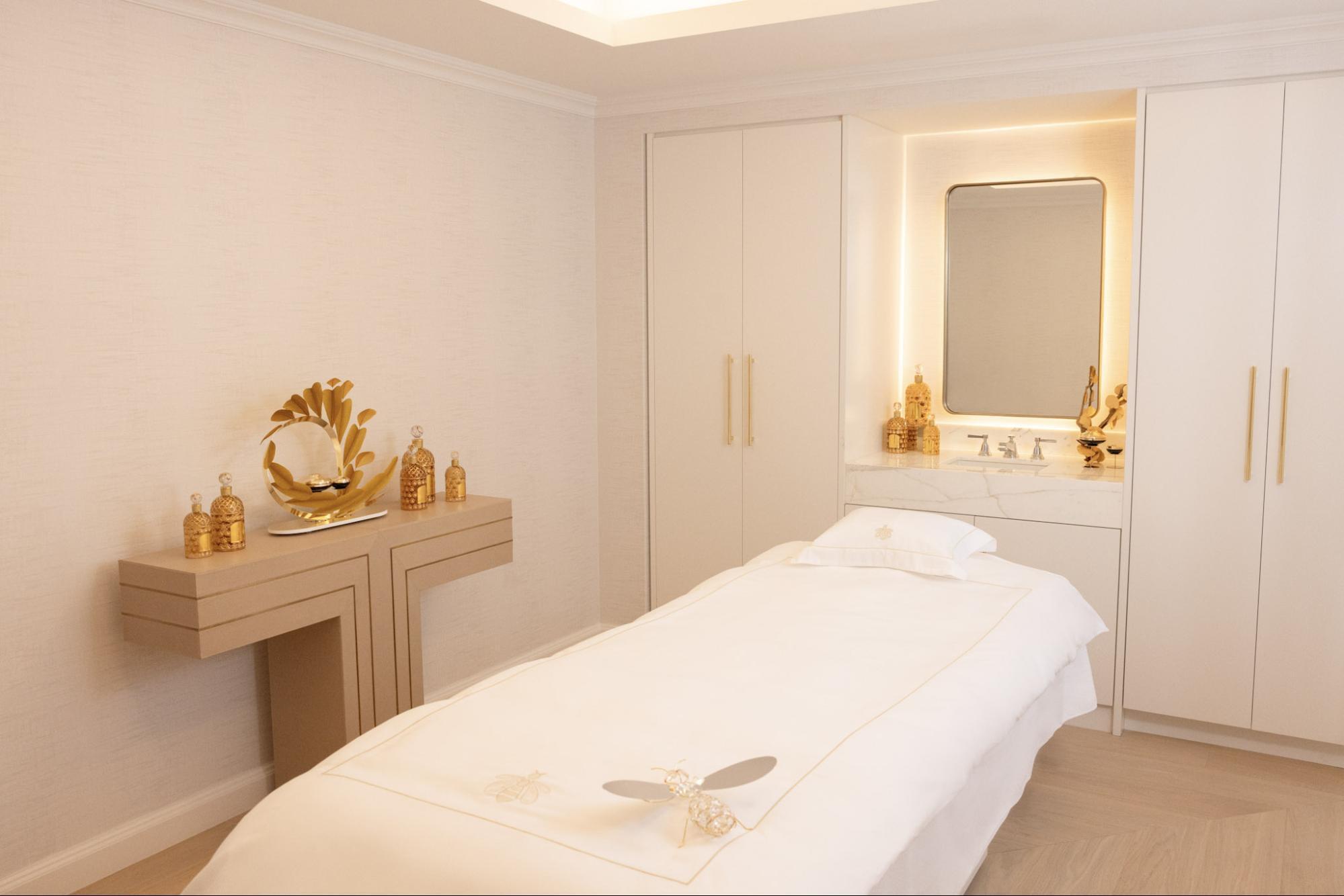 A treatment room with golden decor and a massage bed prepared for a spa session