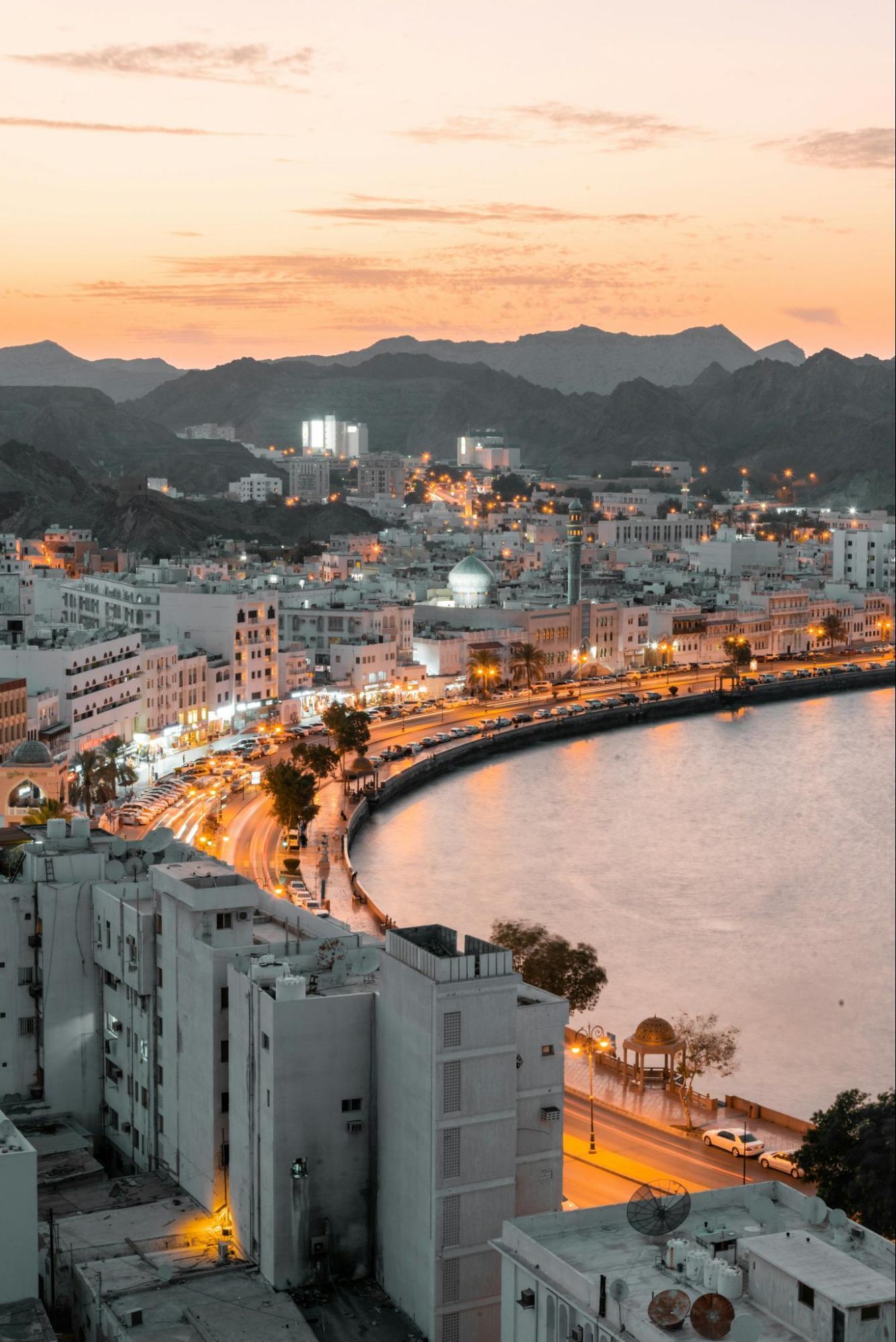 Evening view of Muscat’s coastline and city lights in Oman