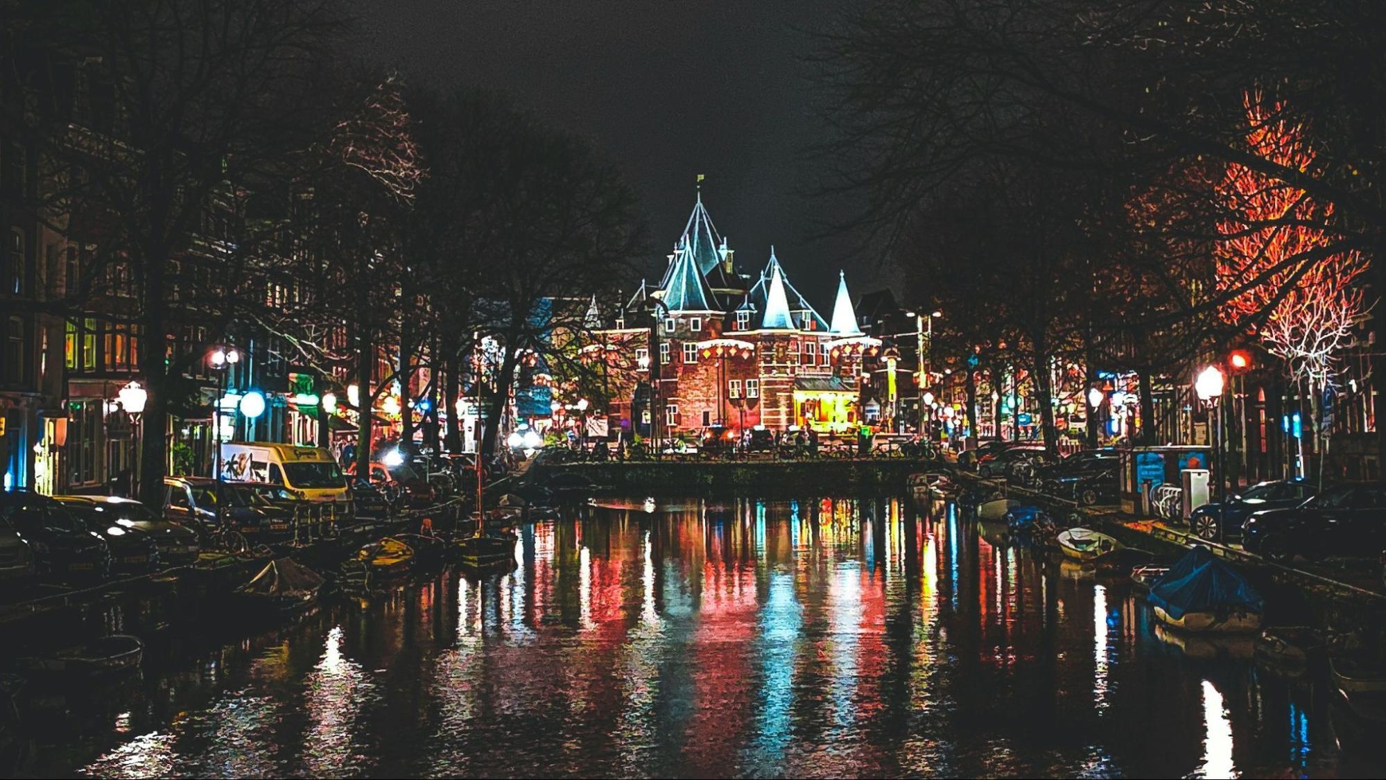Traditional canal houses reflecting in the evening water in Amsterdam’s city center