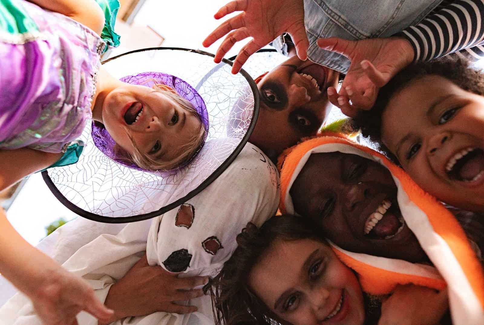 Children in Halloween costumes laughing together at a celebration