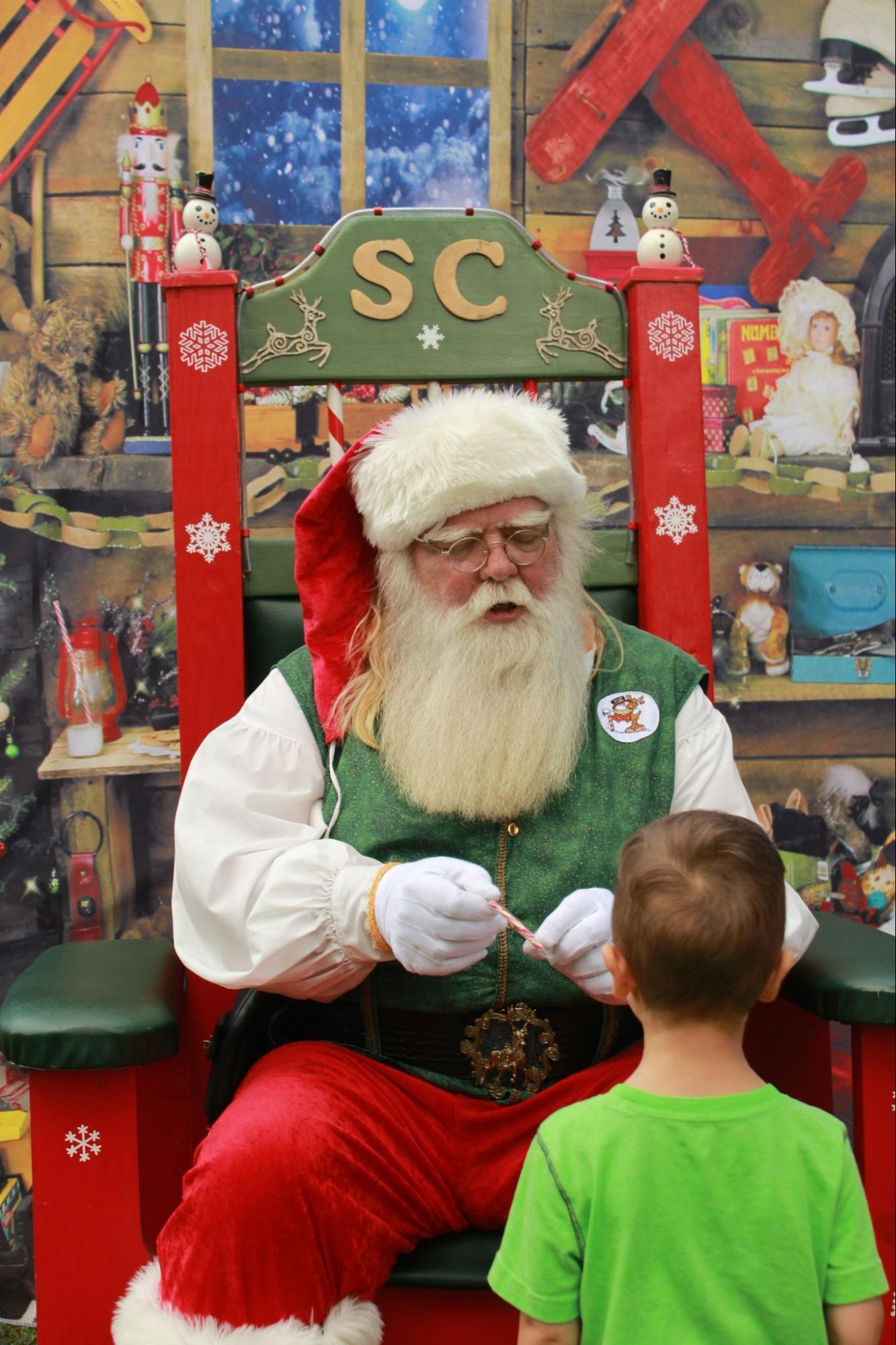 Santa Claus talking to a child during a Christmas event