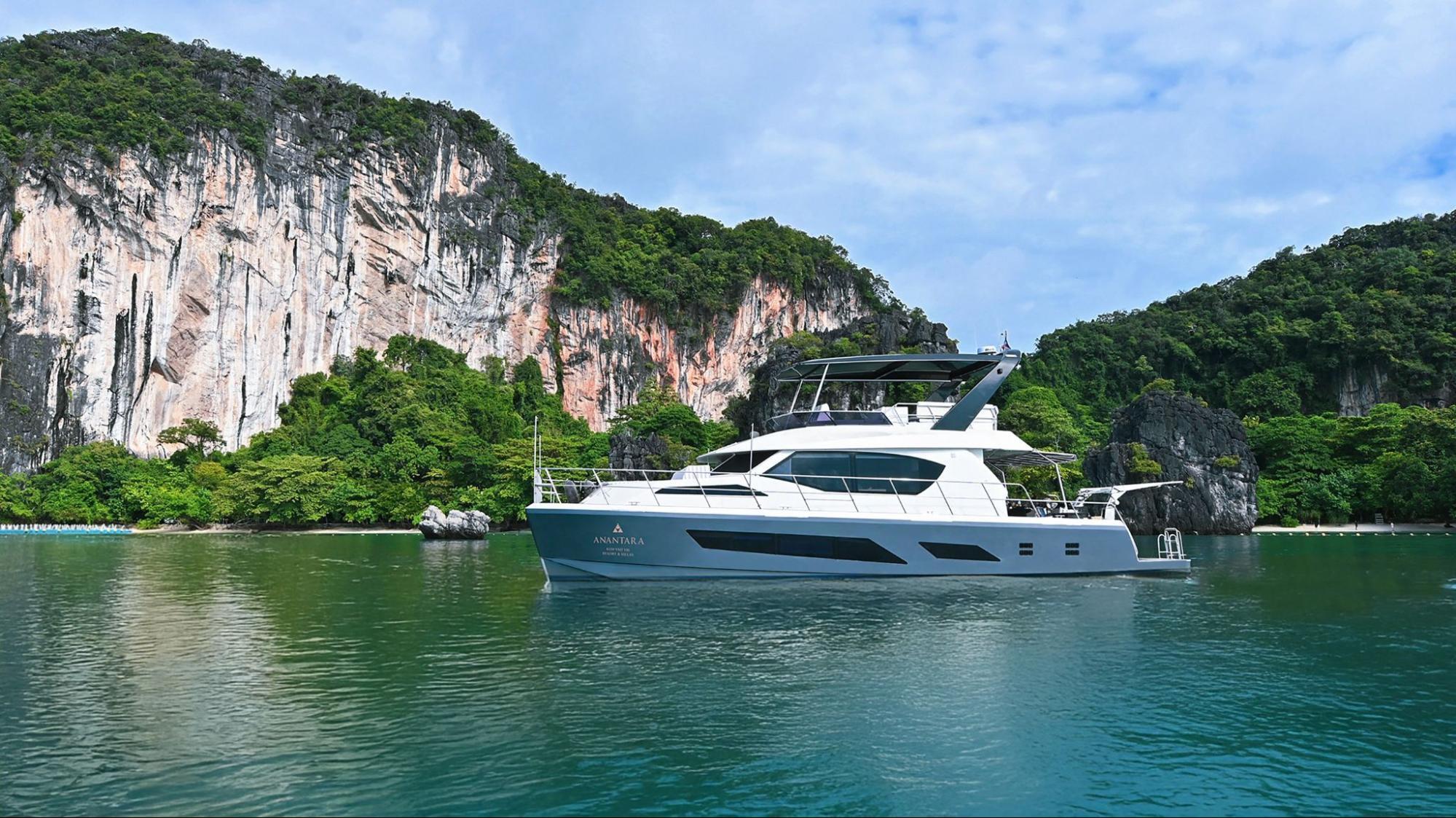 Luxury yacht cruising near limestone cliffs in Phang Nga Bay