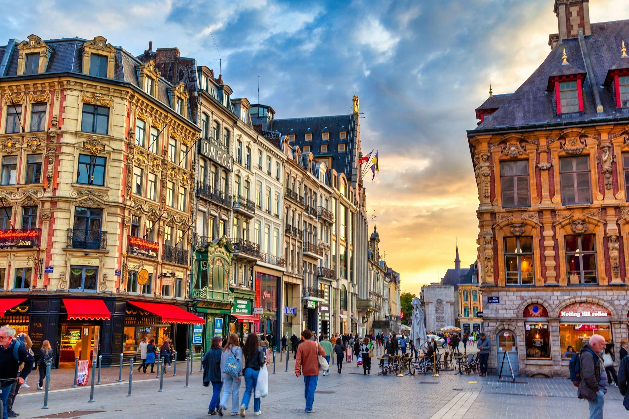 Colorful historic buildings and busy streets in Lille, France at sunset