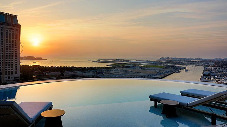 Rooftop infinity pool overlooking Dubai Marina at sunset