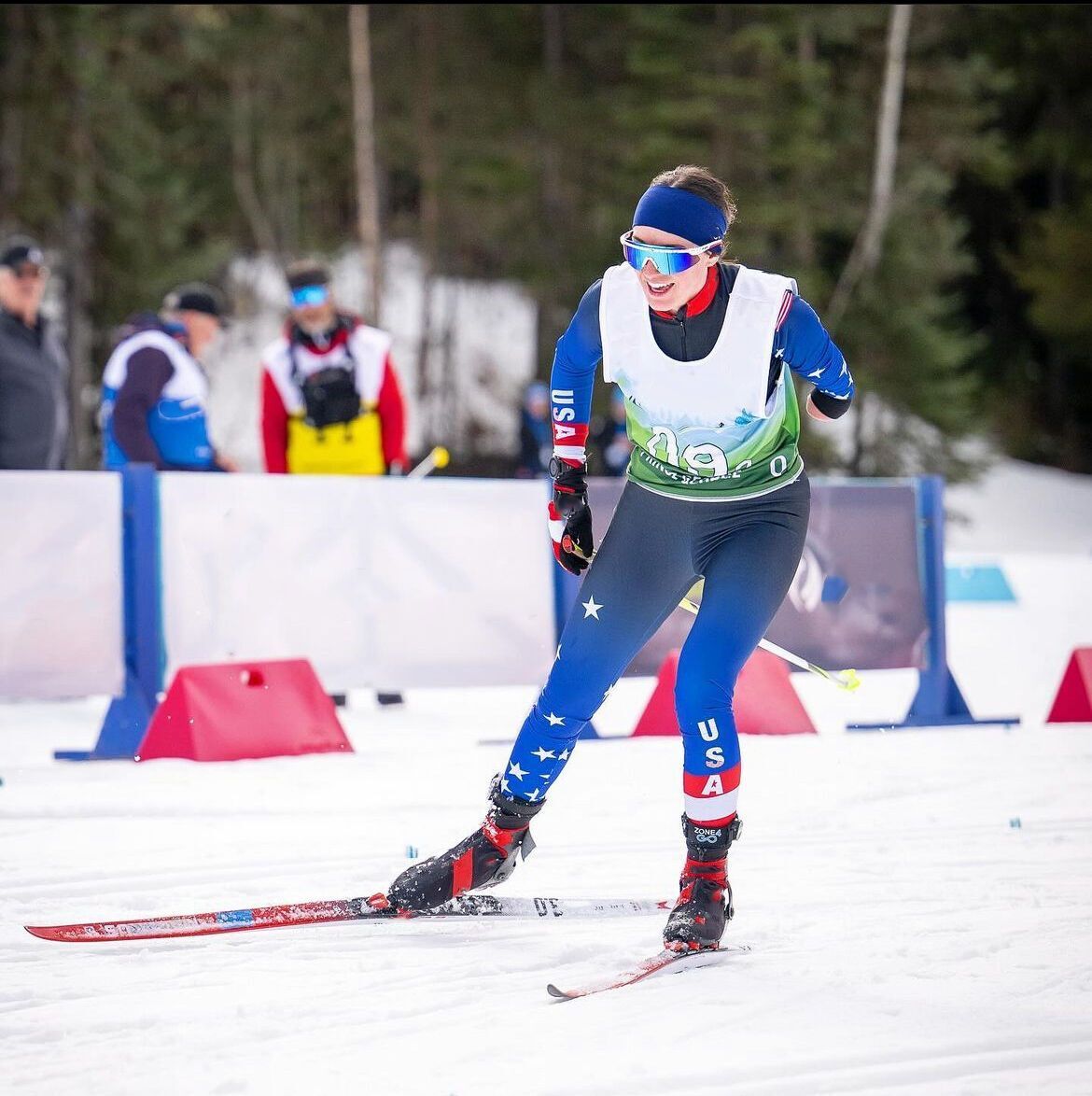 Cross-country skier in USA uniform competing on a snowy course