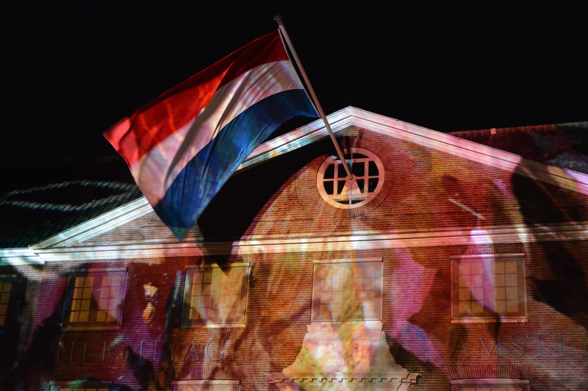 Dutch flag above a building illuminated by festival light projections