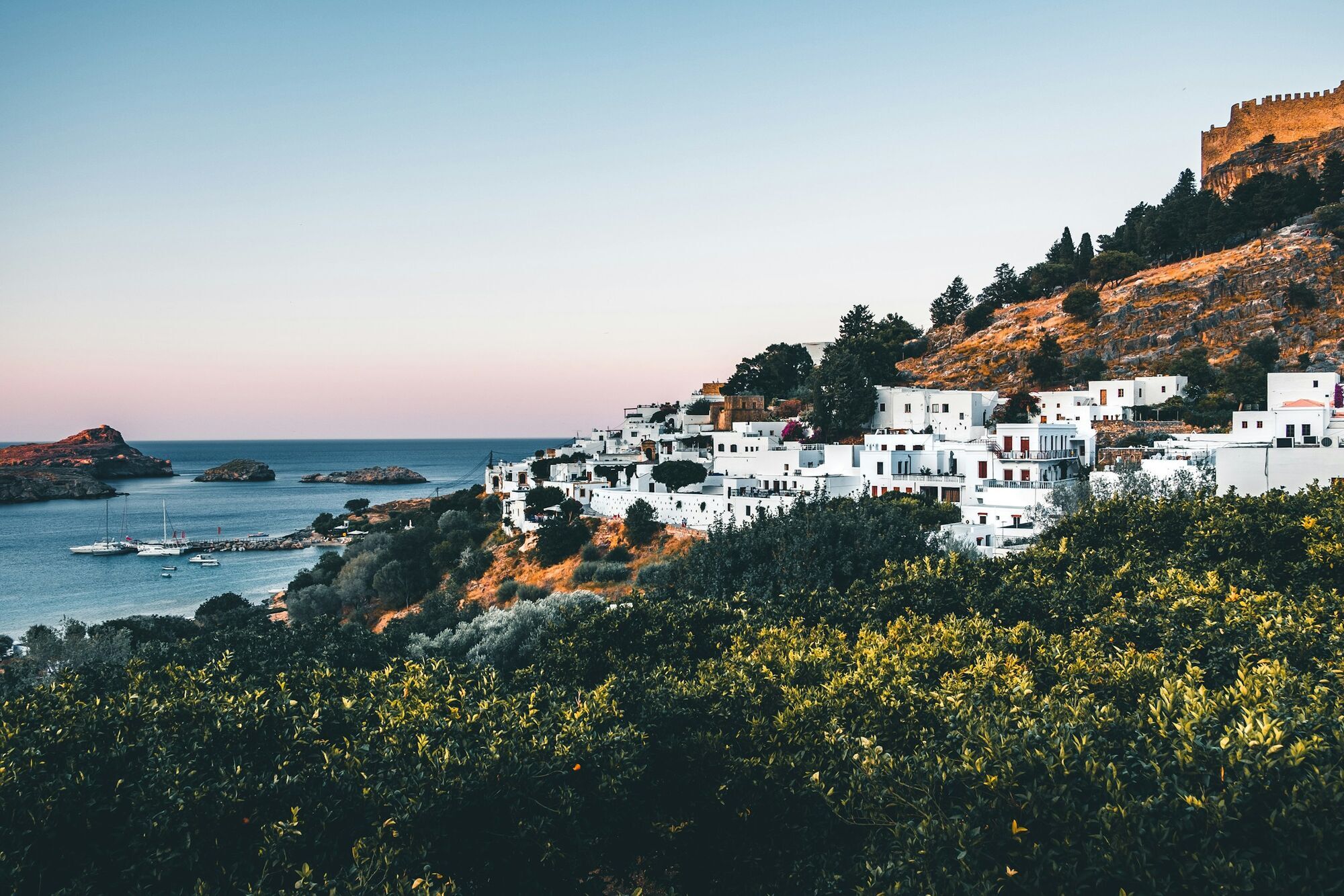Coastal view of Rhodes with white houses and rocky hills