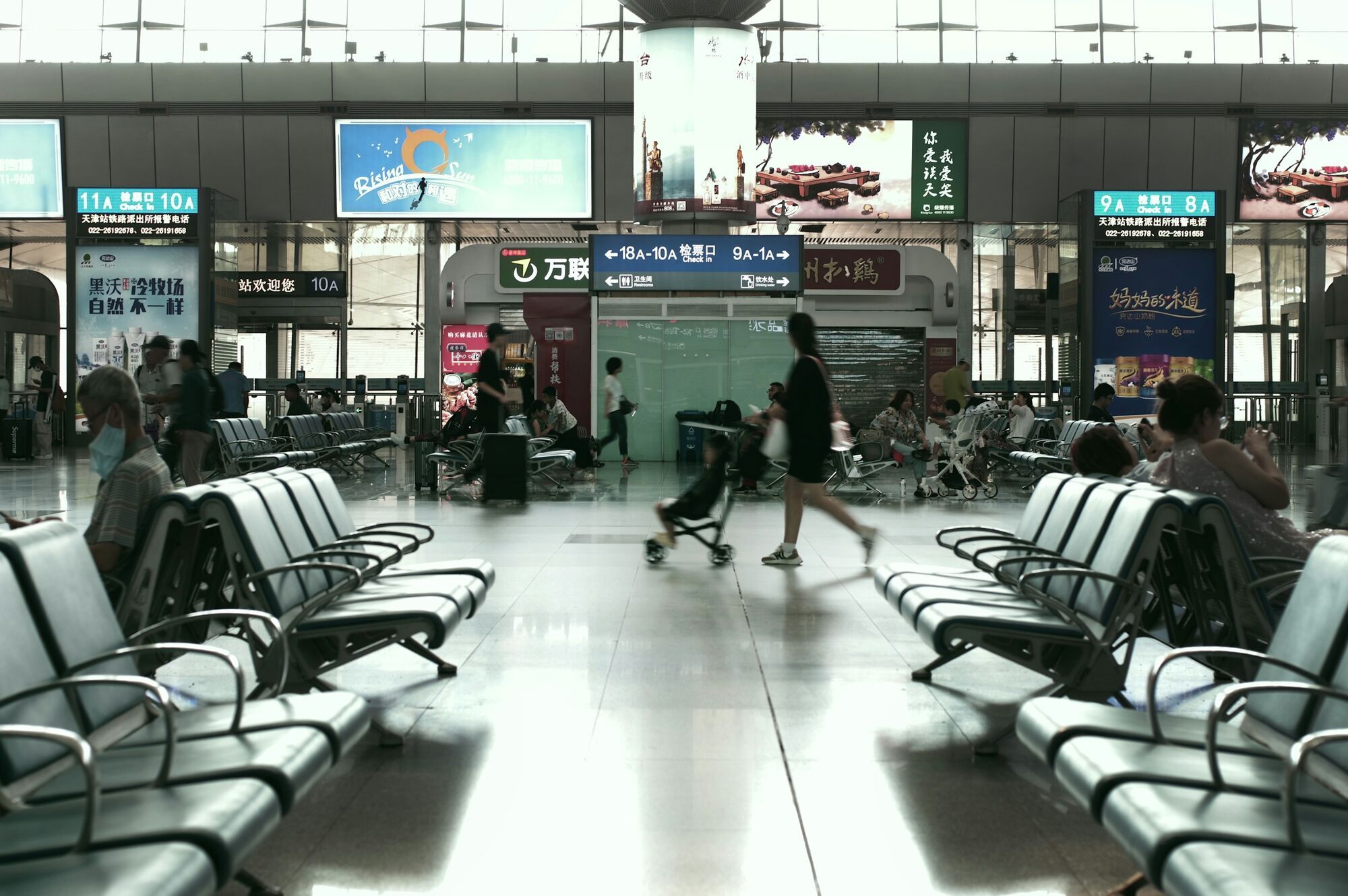 Passengers sitting and walking in an airport waiting area