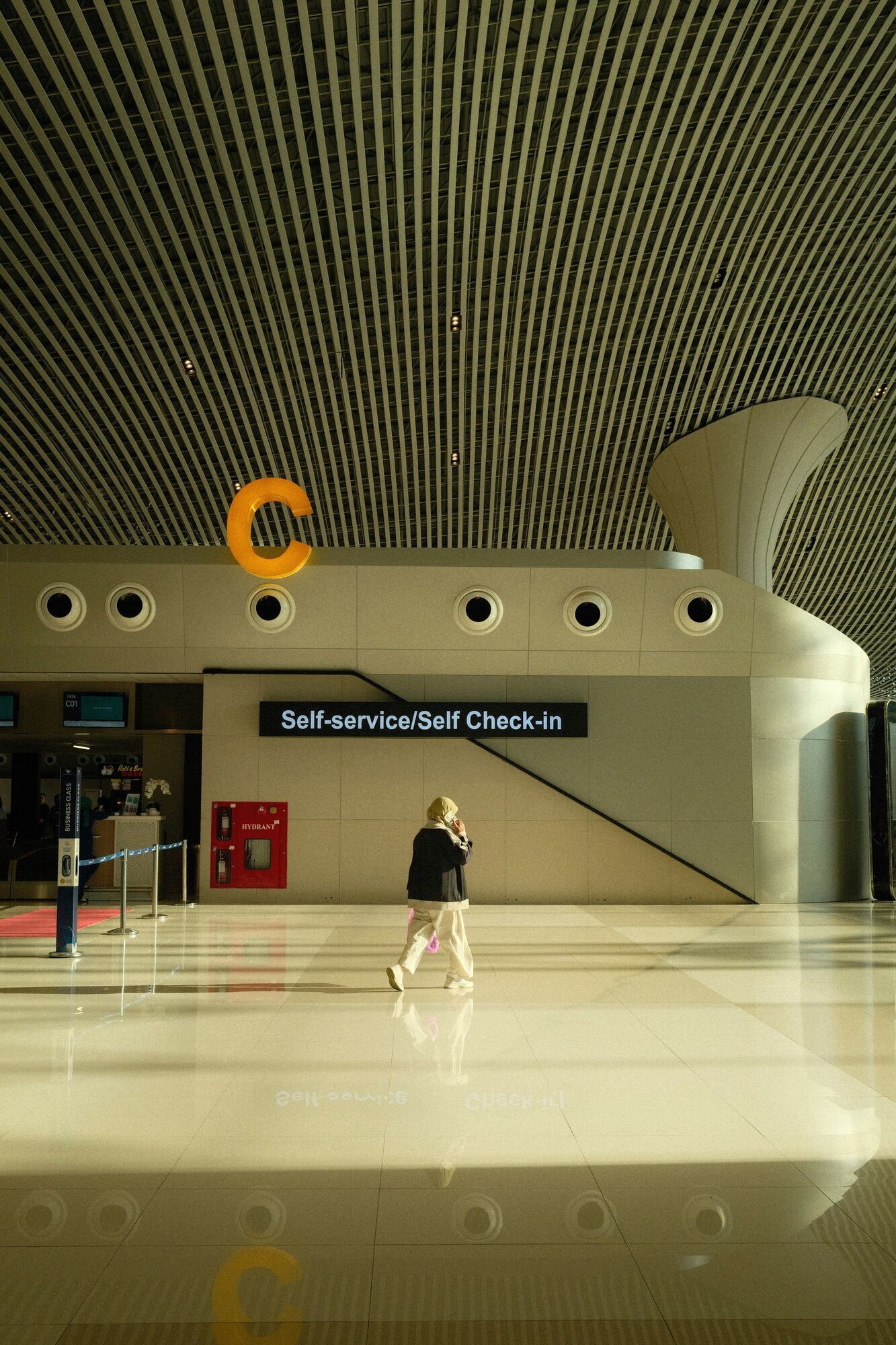 Passenger walking past self-service check-in area at the airport
