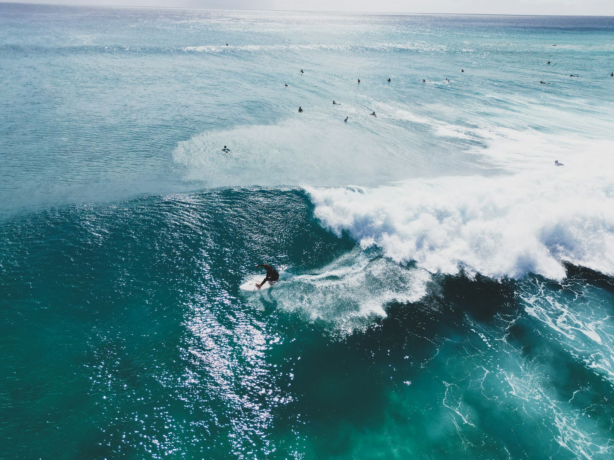 Surfer riding a turquoise wave in Fuerteventura