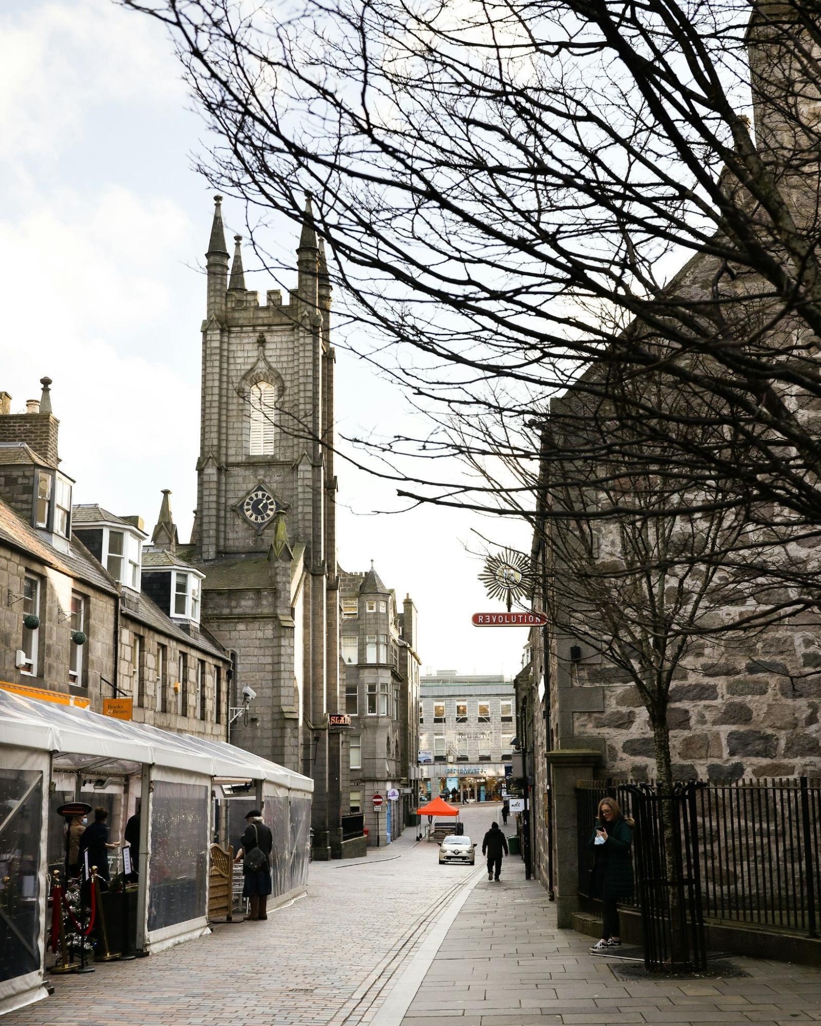 Historic street view of Aberdeen city centre with a clock tower in the background