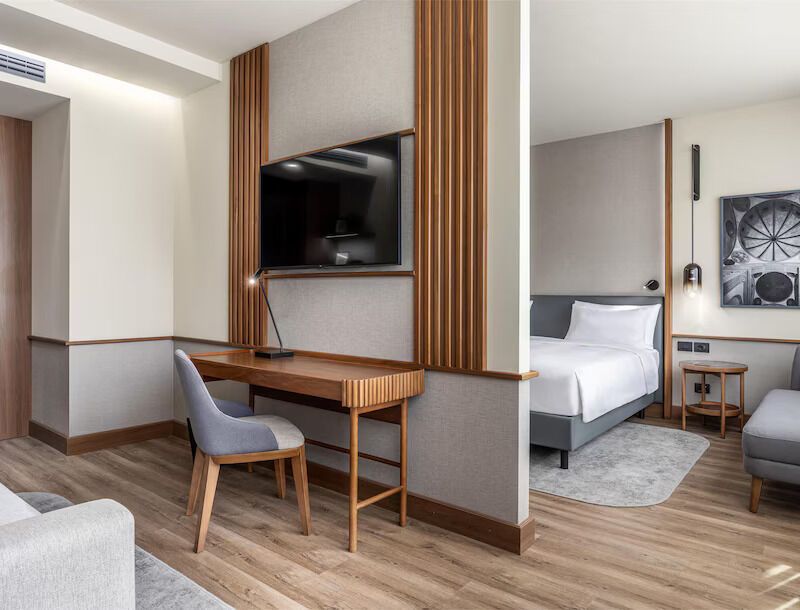 Modern hotel suite with bedroom and workspace