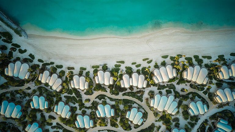 Aerial view of beachfront villas and turquoise shoreline on Shura Island