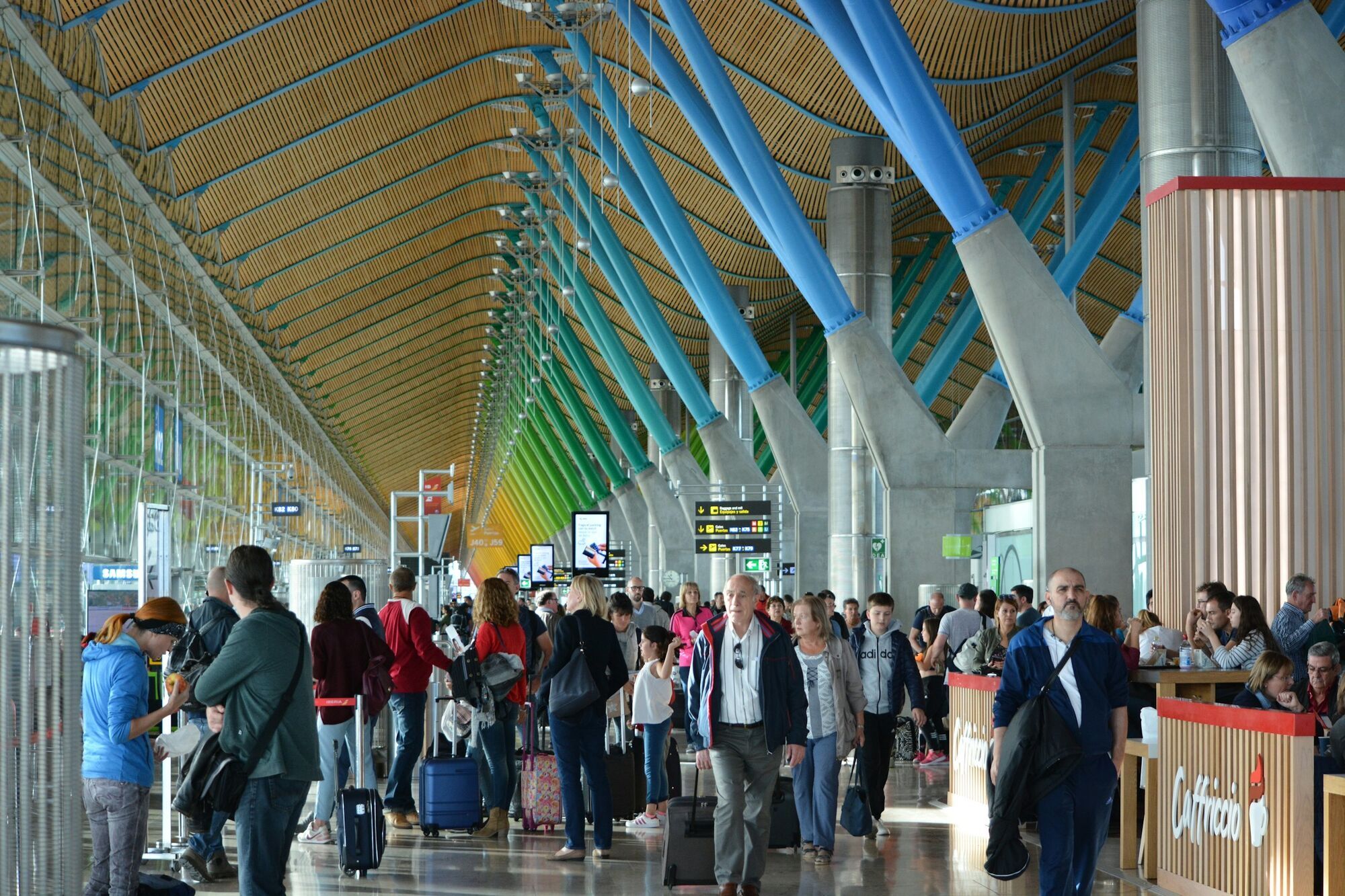 Passengers waiting inside a busy European airport terminal