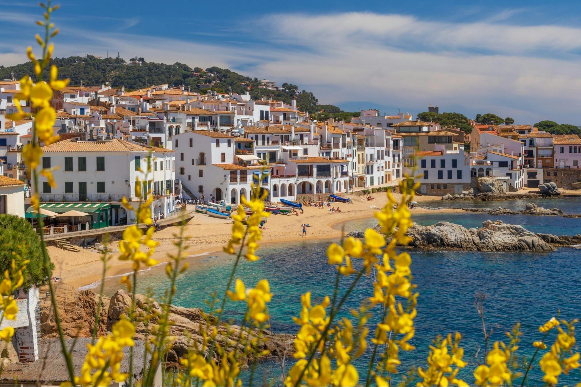 Coastal town with beach and historic buildings in southern Europe.