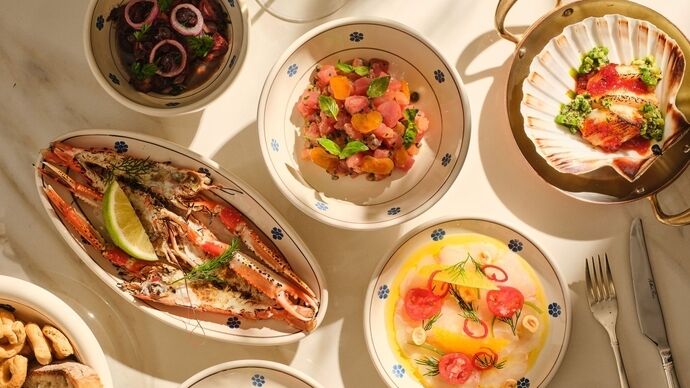A selection of seafood and seasonal dishes arranged on a table in warm natural light