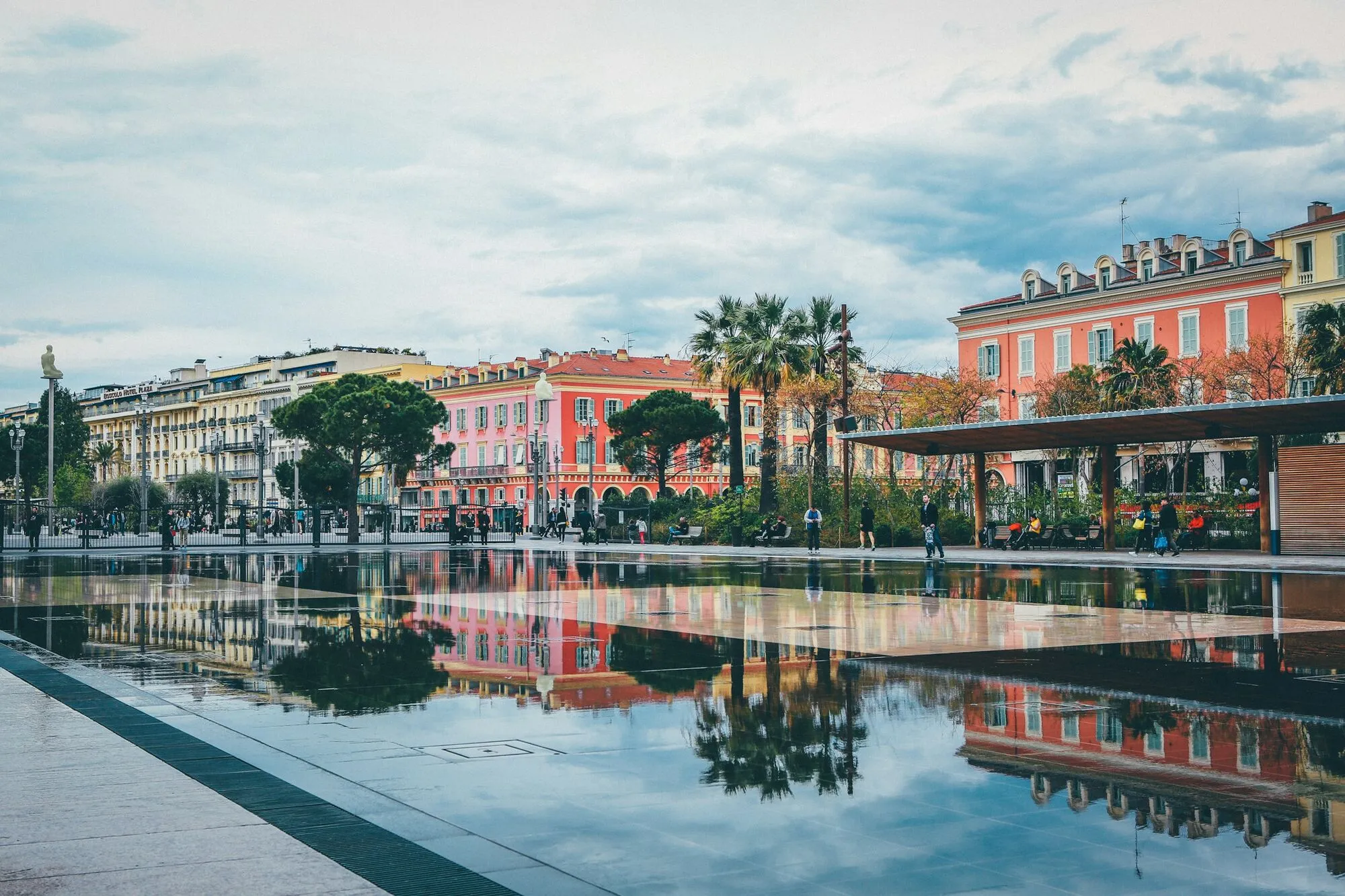 Colorful buildings reflecting in the water at Promenade du Paillon, Nice, France