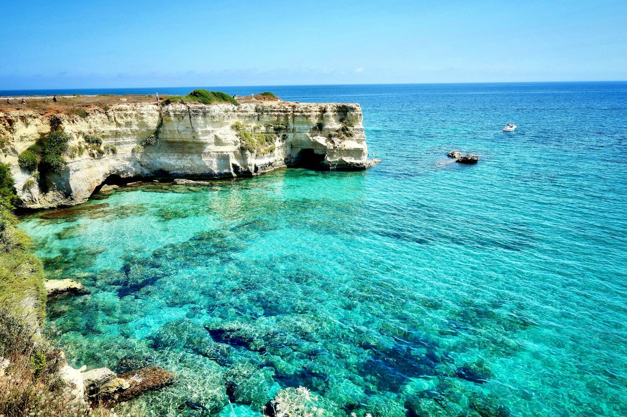 Crystal-clear turquoise waters and limestone cliffs along the Puglia coastline in southern Italy