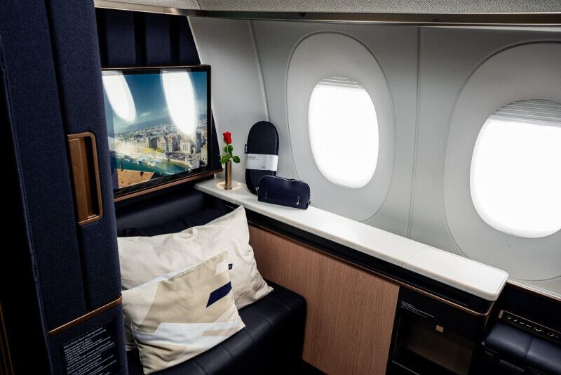 A luxurious Lufthansa First Class suite featuring a private seating area, entertainment screen, and premium amenities