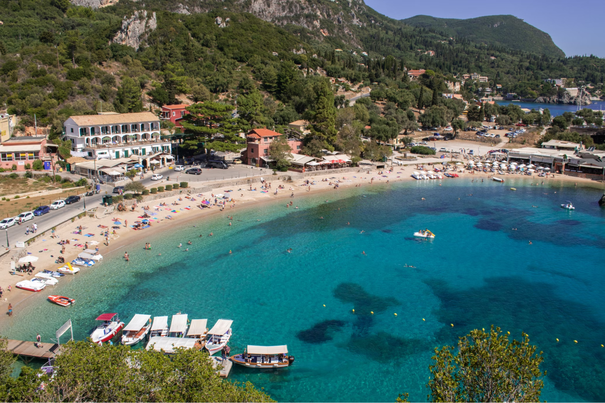 Beachfront in Corfu with clear water and moored boats