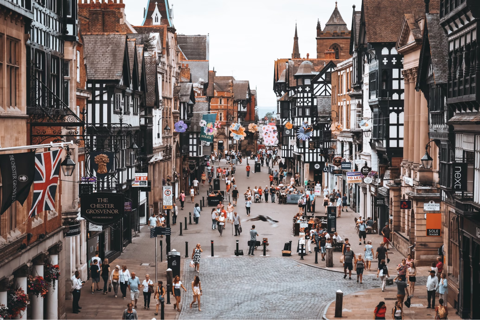 Busy pedestrian street in Chester with historic buildings and shops