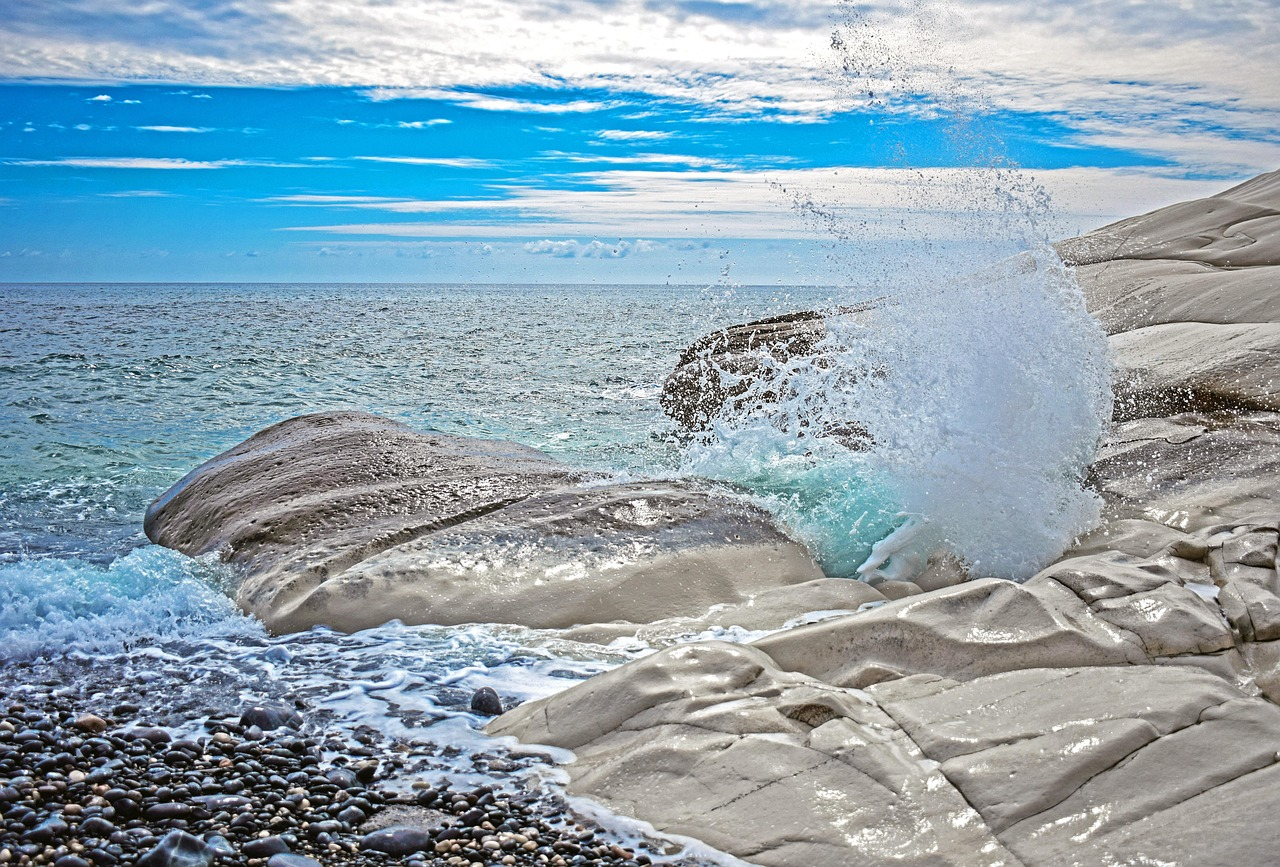 Waves splash against the smooth rocks at Agios Prokopios Beach on Naxos, Greece