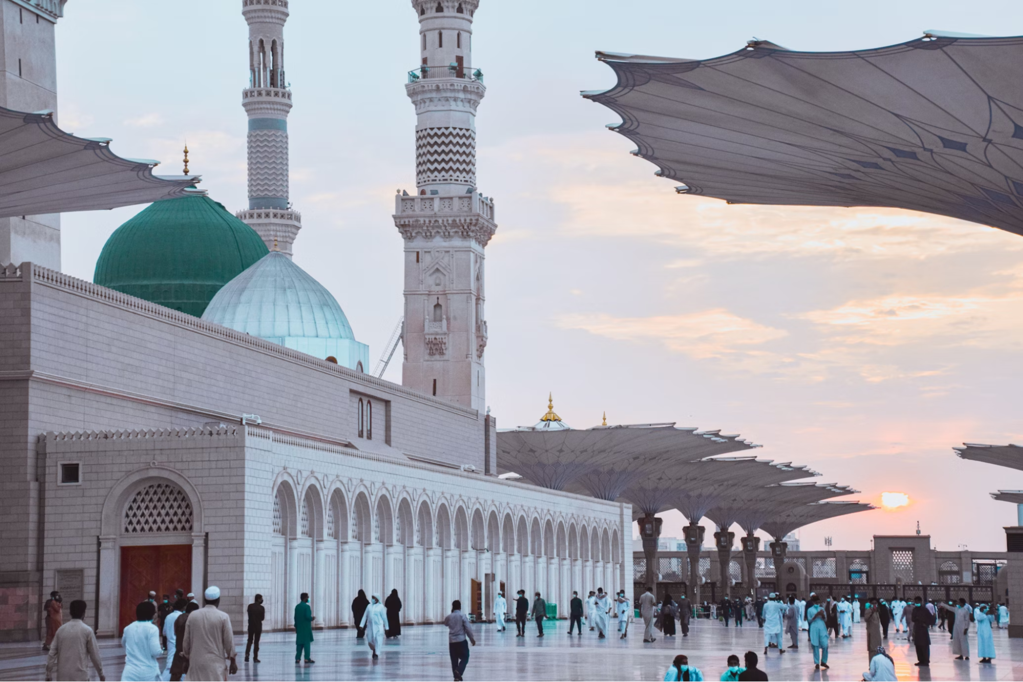 Pilgrims walking near the Prophet's Mosque in Medina at sunset