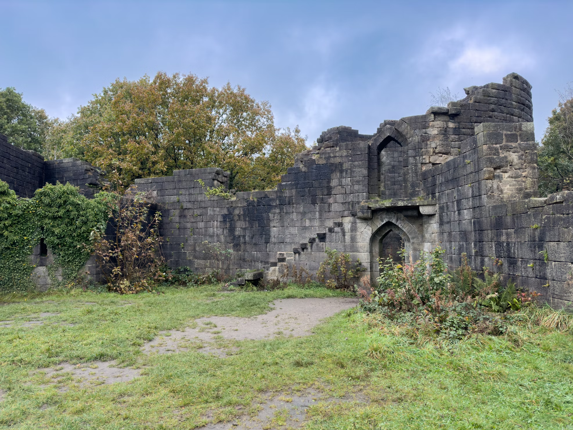 Stone ruins in Rivington Country Park with greenery and cloudy sky