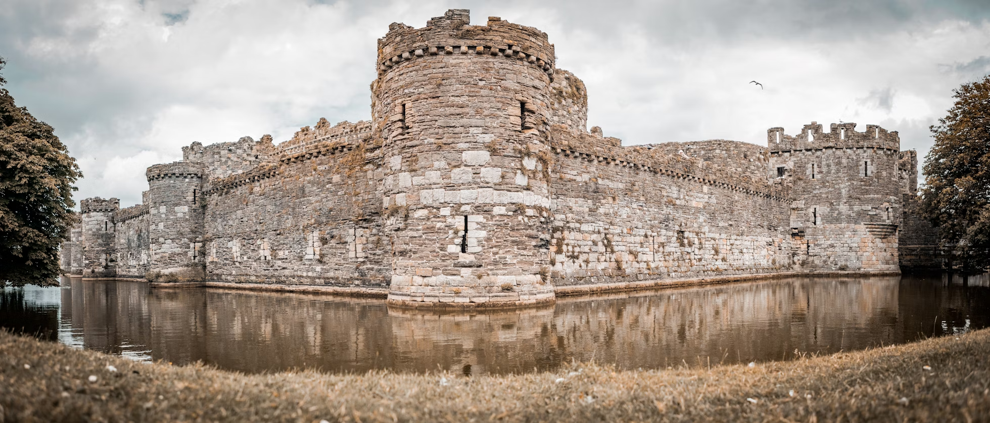 Beaumaris Castle near the water with a cloudy sky