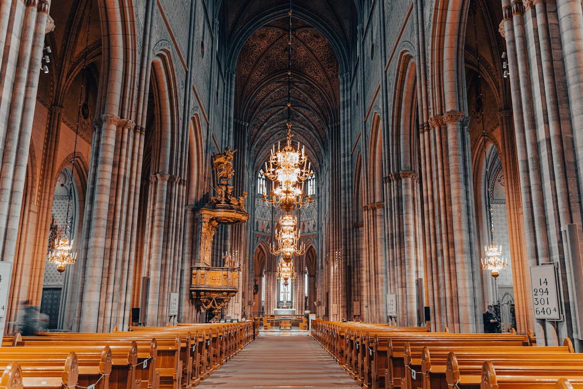 Interior view of Uppsala Cathedral with high arches and chandeliers