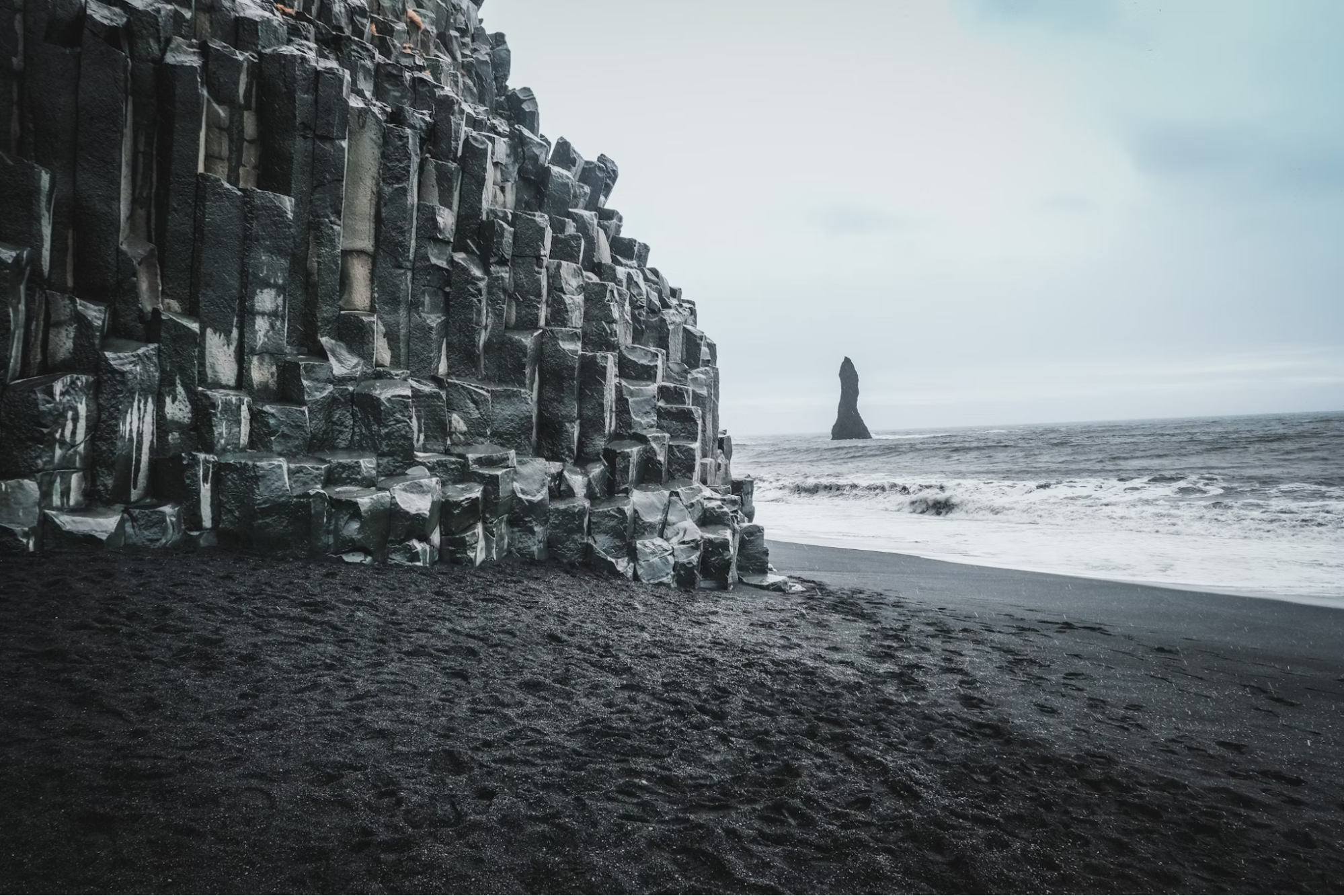 Basalt columns and black sand at Reynisfjara Beach in Iceland