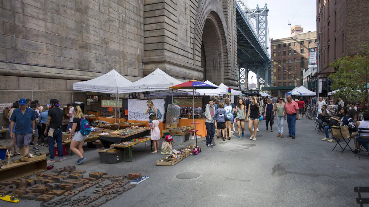 Brooklyn Flea market beneath Manhattan Bridge with crowds browsing vendor stalls