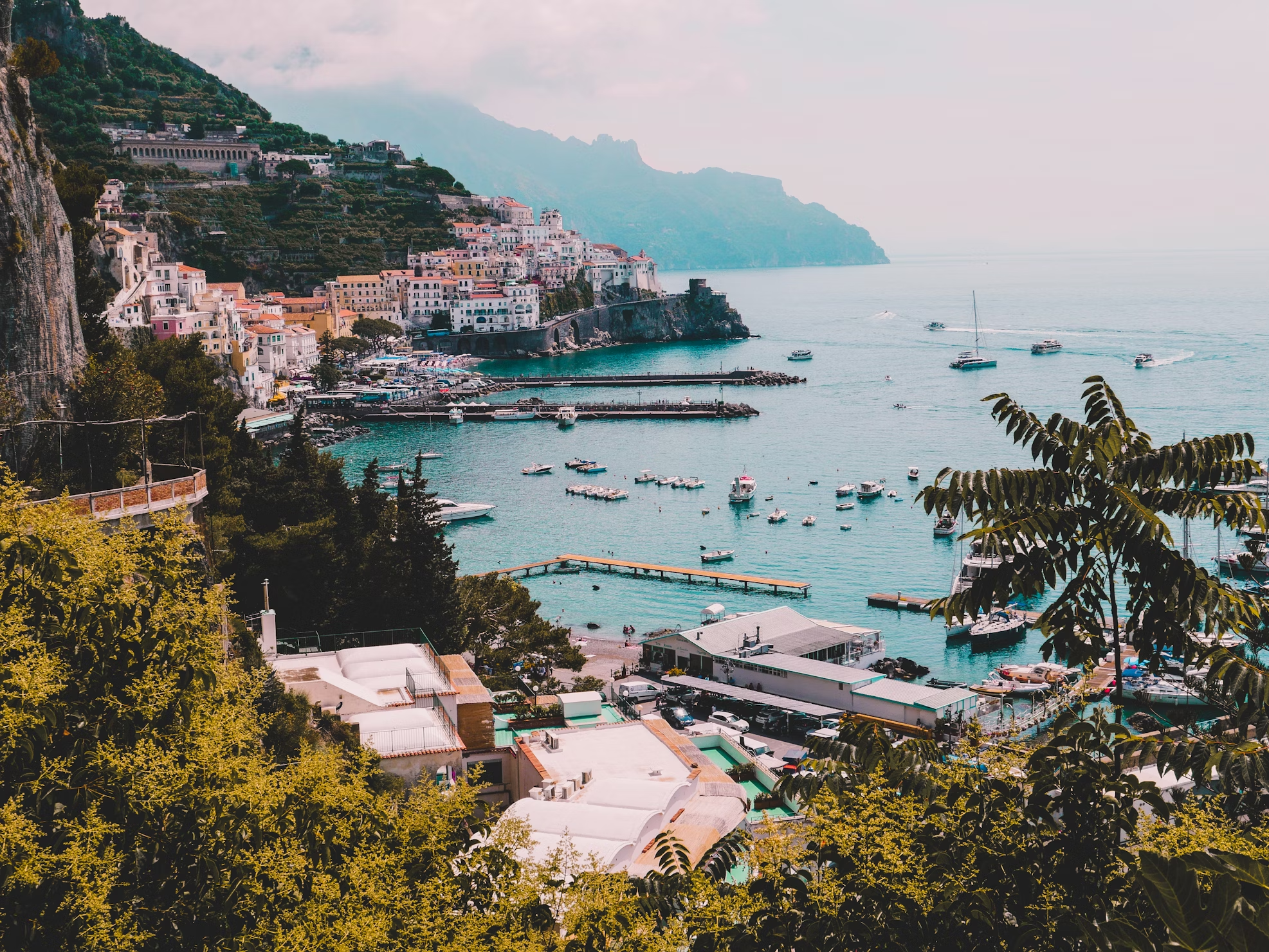 View of Amalfi Coast with hillside buildings and boats in the bay