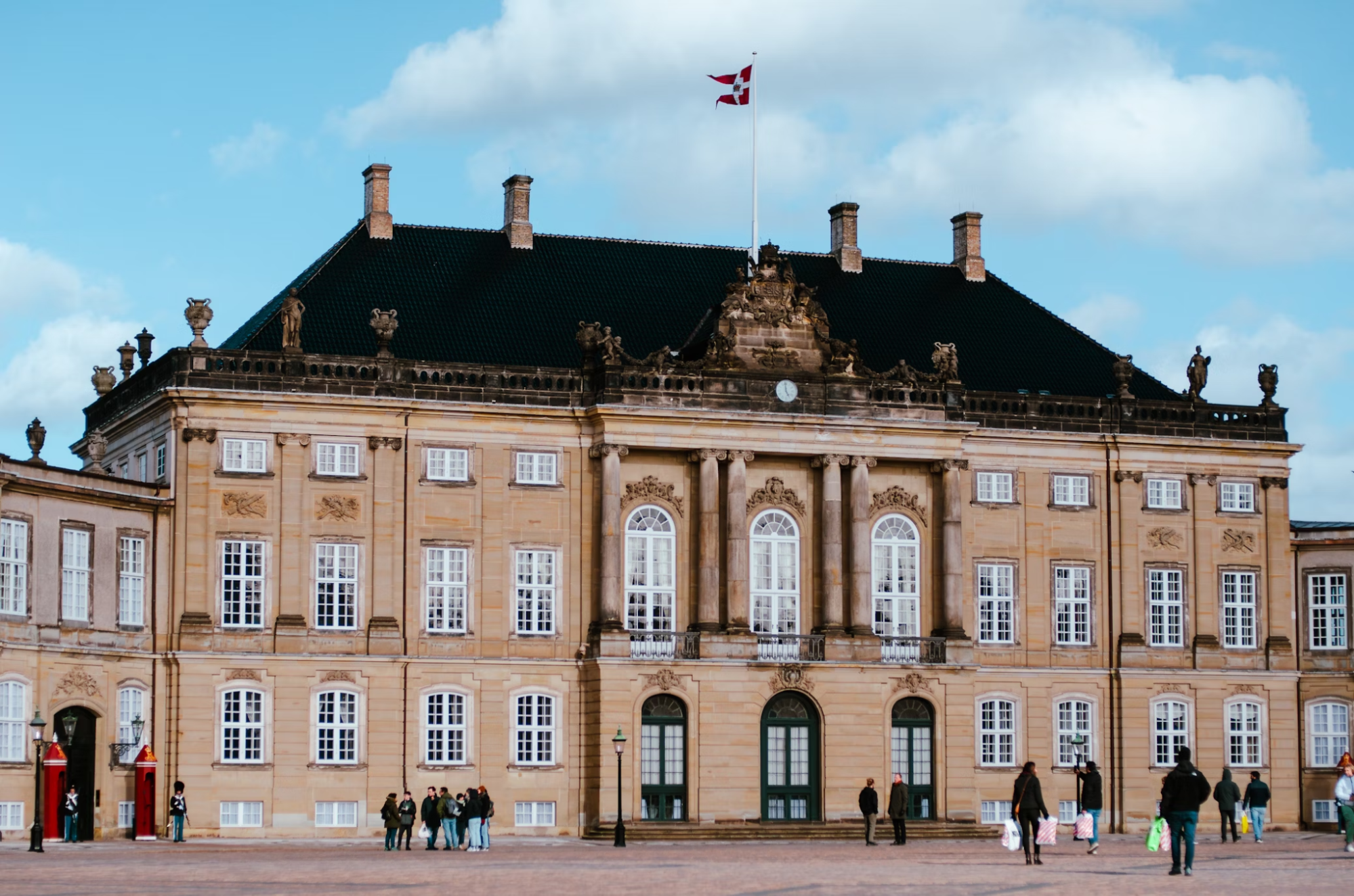 Amalienborg Palace with Danish flag and visitors outside