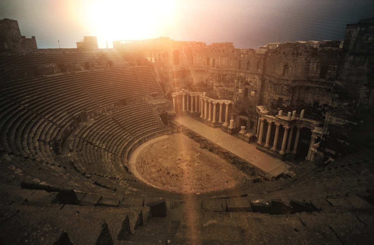 Ancient Roman amphitheatre in Bosra, Syria, with sunlight streaming over the ruins